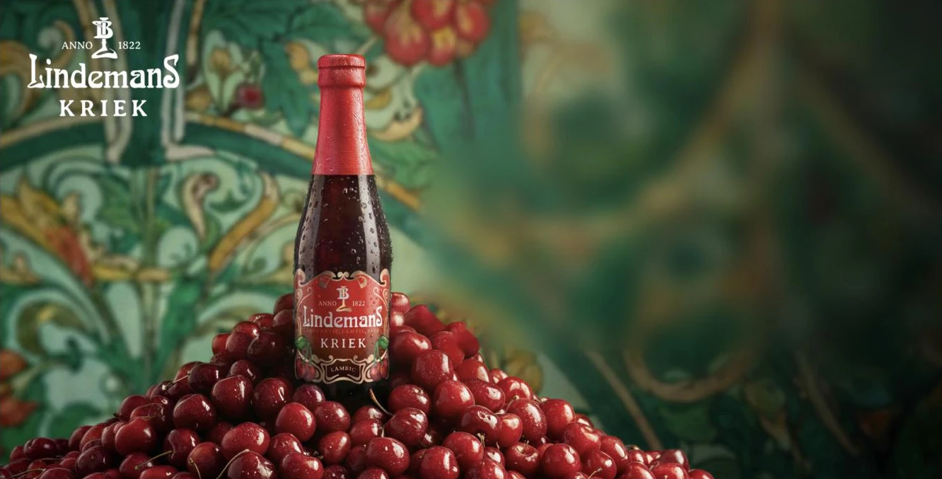Lindemans Kriek, cerveza belga de cereza, sobre una montaña de cerezas frescas
